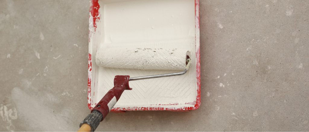 Paint roller in white paint tray