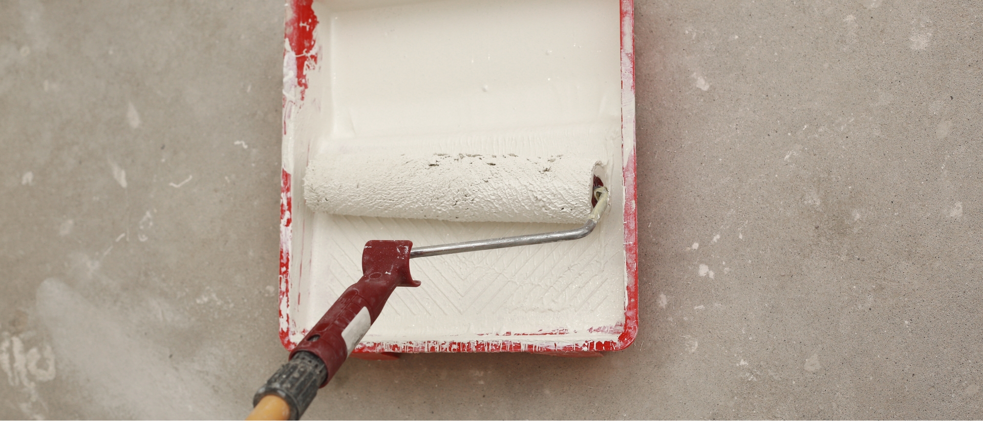 Paint roller in white paint tray