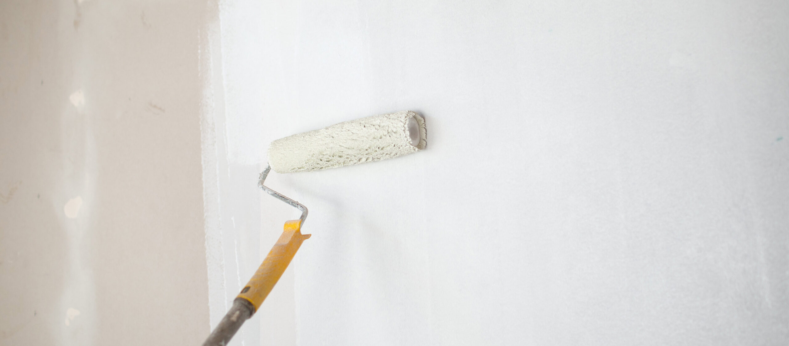 wall roller applying white paint