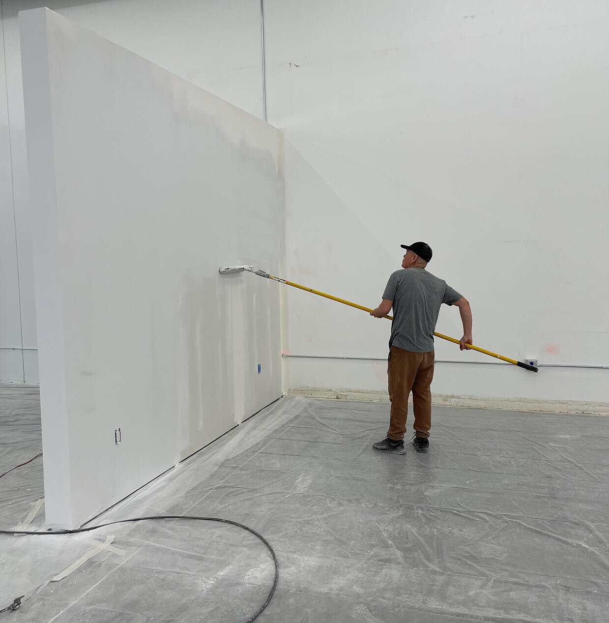painter applying paint to an office wall