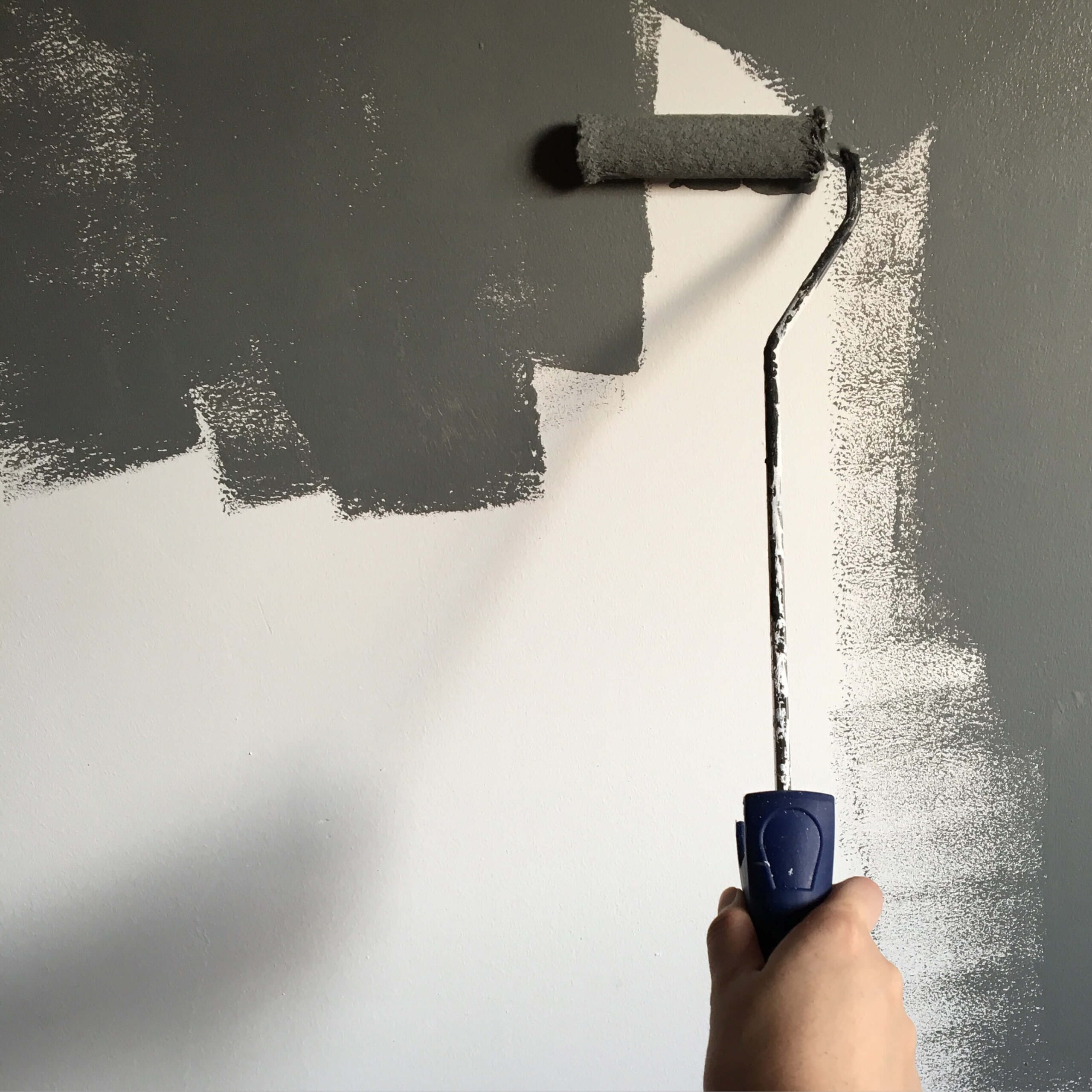 dark gray paint applied to wall with paint roller